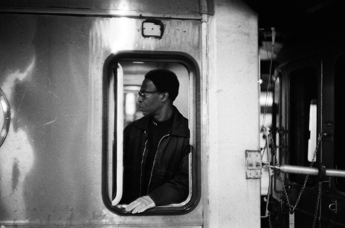 An MTA train conductor in profile, seen through the window of the subway train