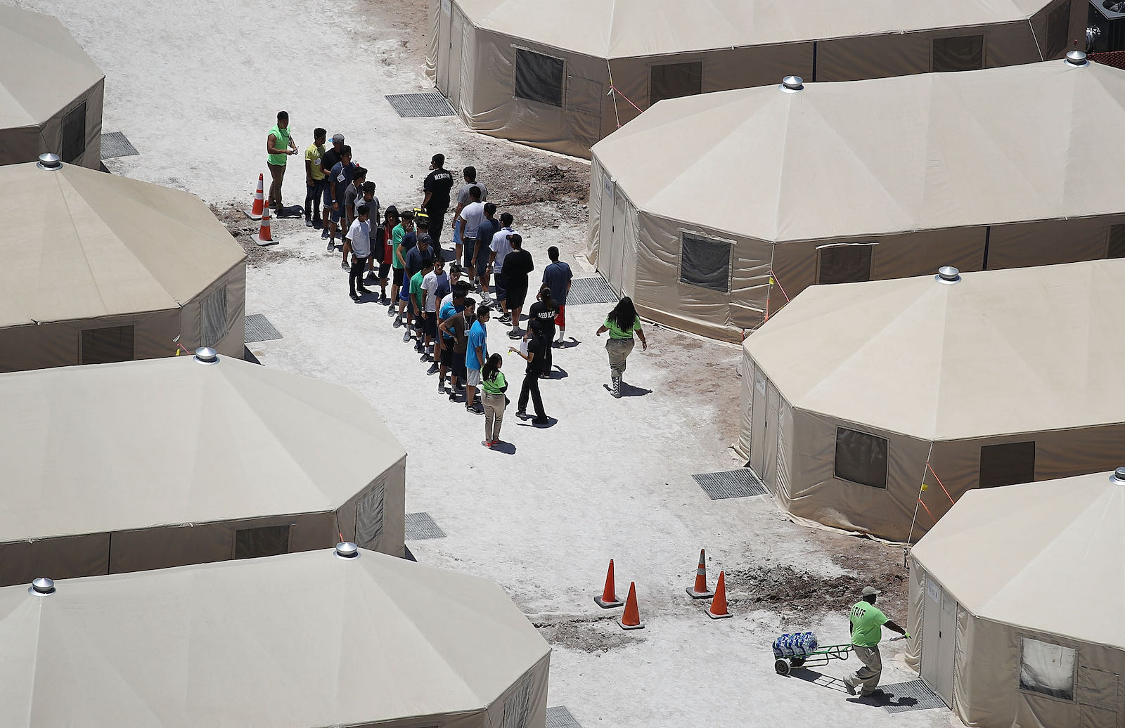 Migrant children lining up at a tent encampment detention facility, Texas, 2018