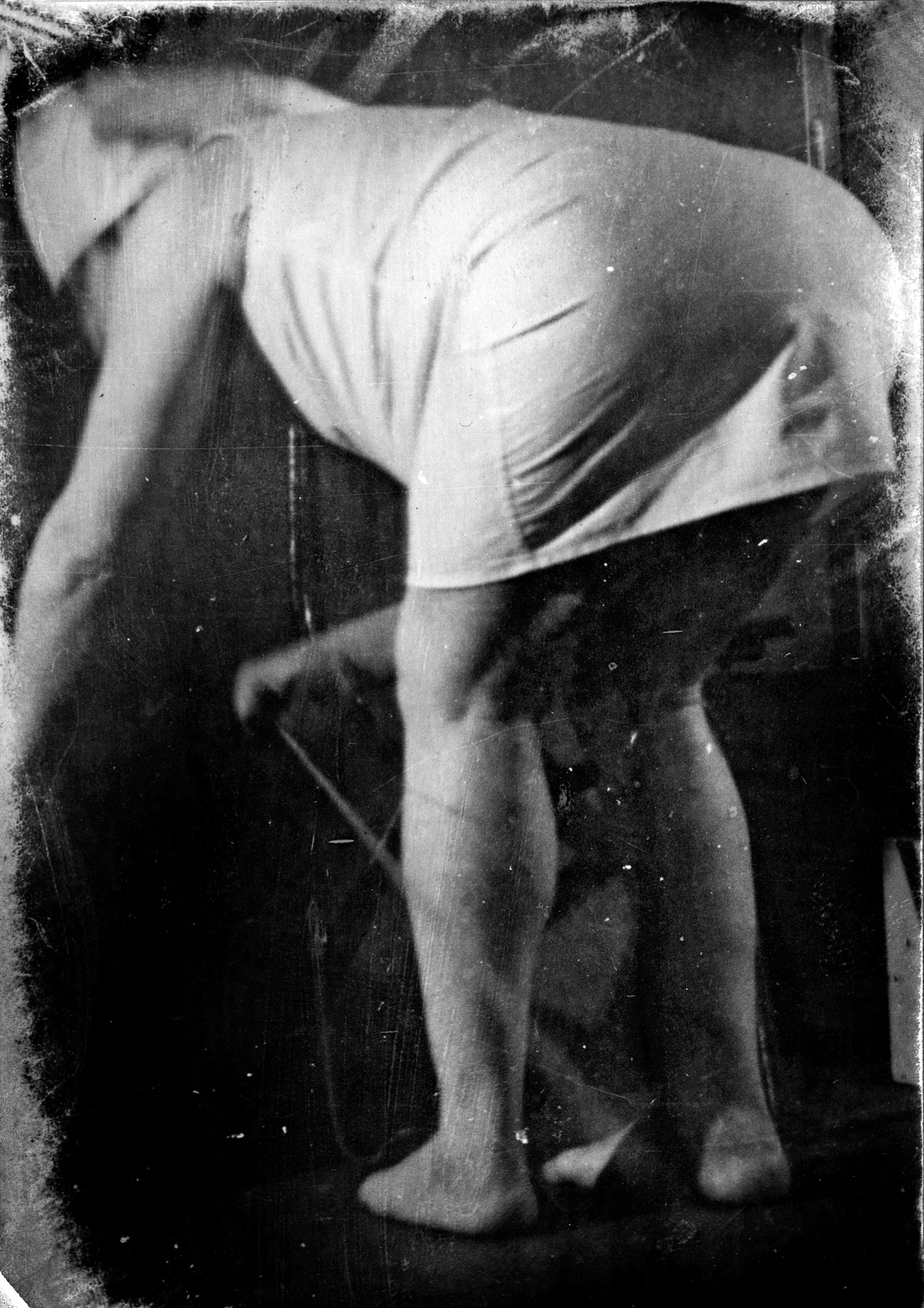 a man in a nurse's uniform bends down away from the camera