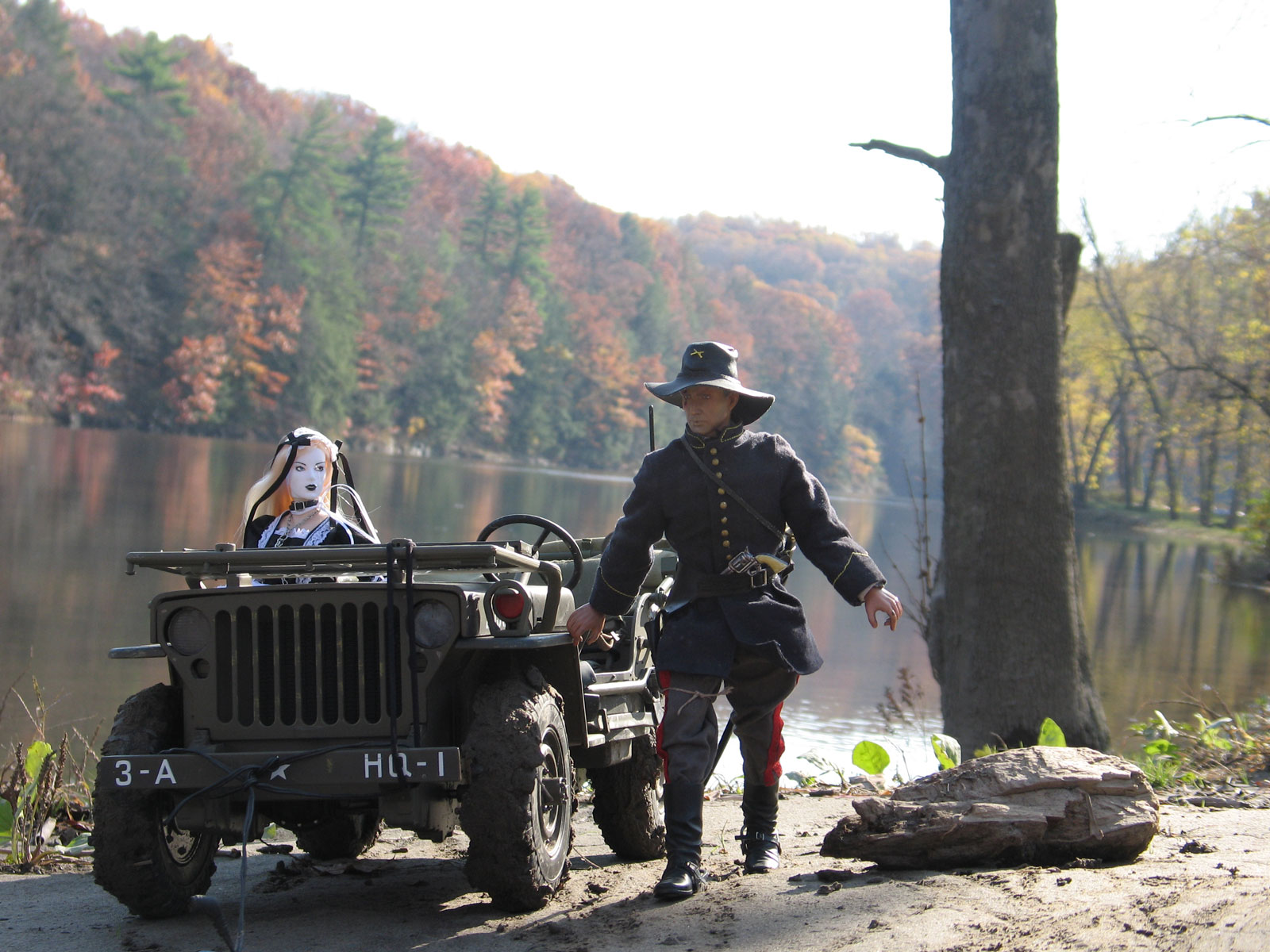 toy soldier leading a toy jeep with a toy woman in it, the backdrop a wooded lake