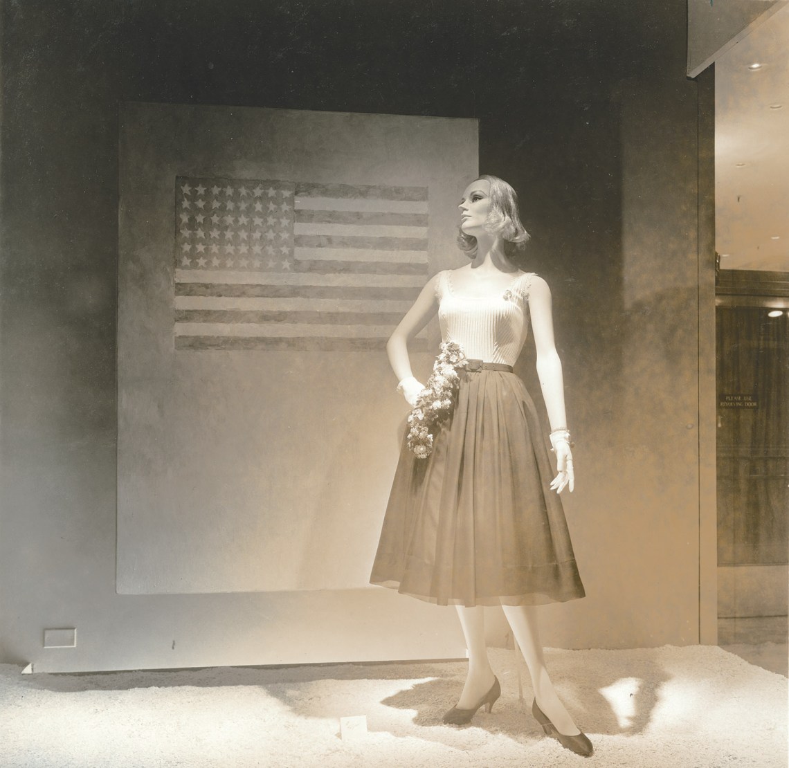 A window display at the Bonwit Teller department store featuring Flag on Orange Field (1957) by Jasper Johns, New York City, 1957