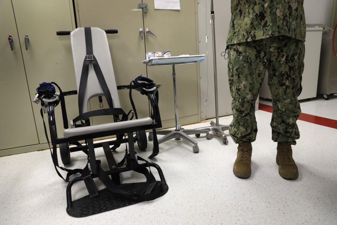 A US Navy doctor with a restraint chair used to force-feed detainees