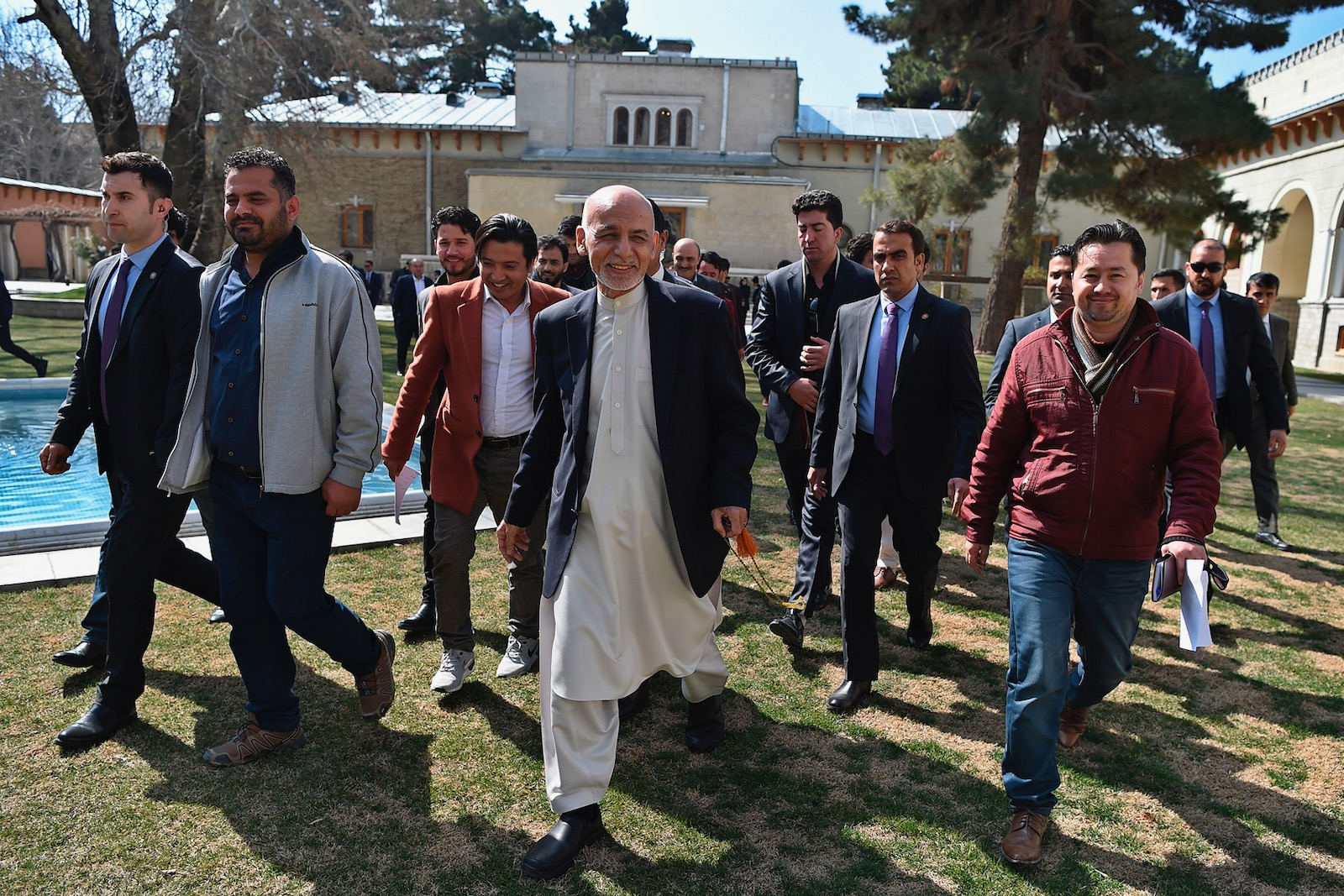 Afghan President Ashraf Ghani walking with journalists