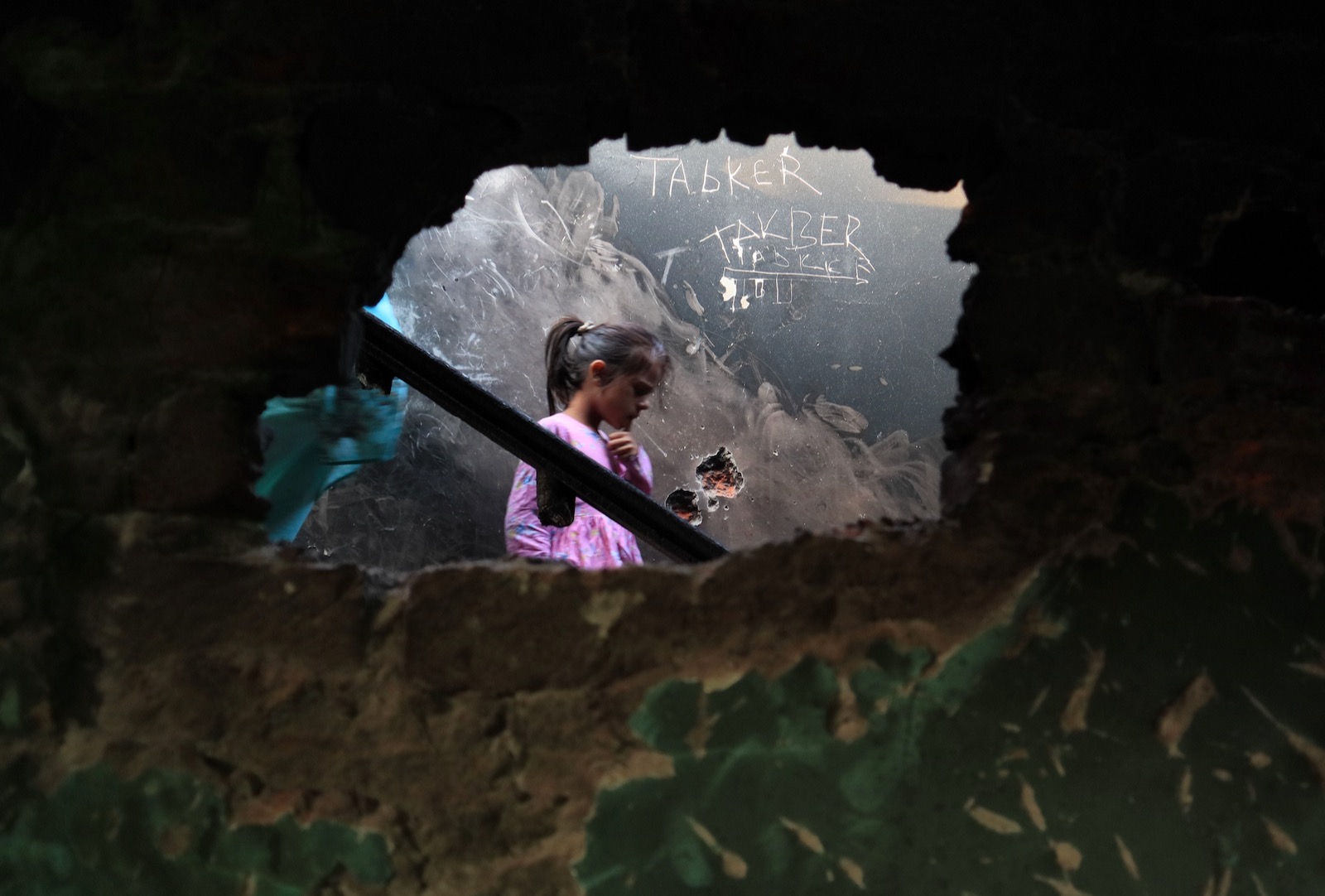 A Kashmiri girl inside a home damaged i fighting