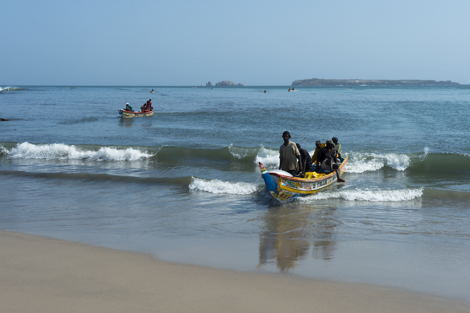 Fishermen in colorful boats returning to shore at a Dakar beach in Senegal, 2013