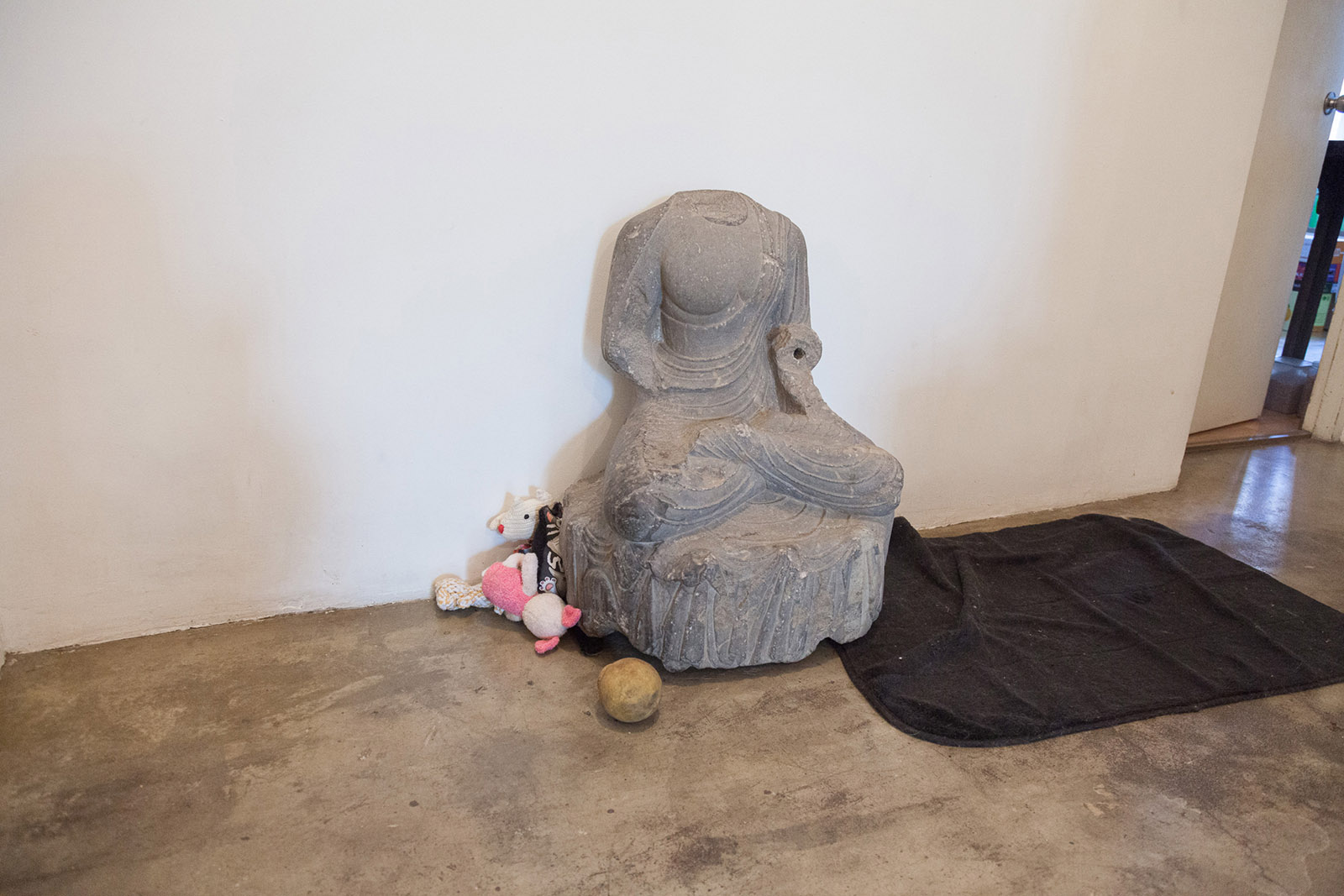 Schist Buddha, toys, and a sleeping mat