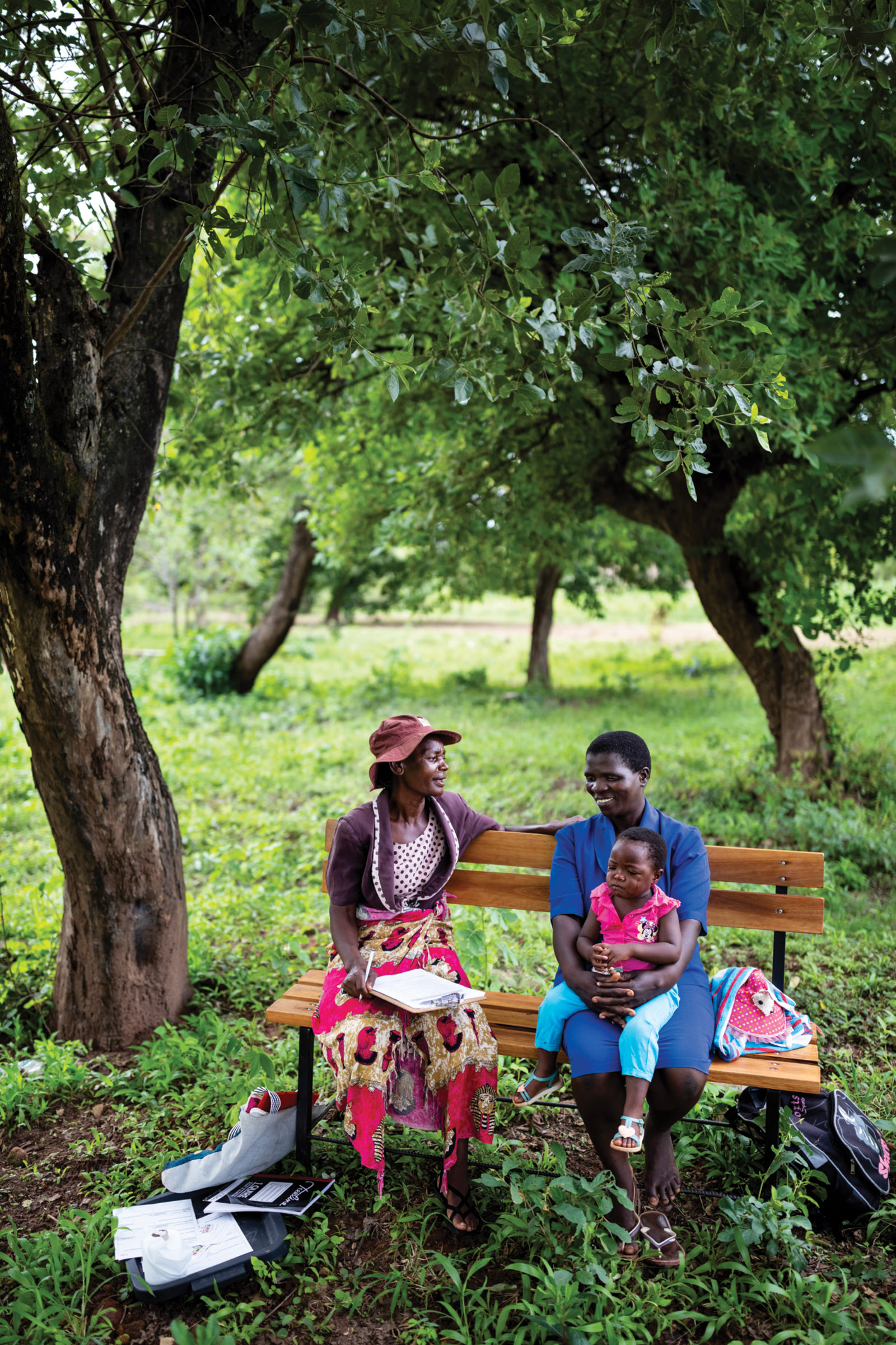 Two adults and a child on friendship bench, Masvingo, Zimbabwe