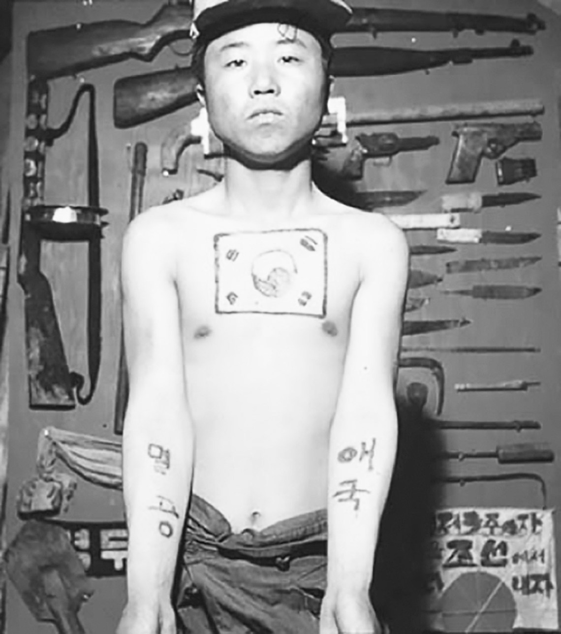 A Korean prisoner of war with tattoos of the national flag of South Korea and the words ‘Patriotism’ and ‘Eradicate Communists'