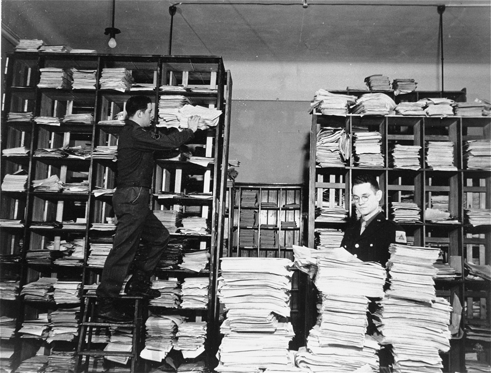 American army staffers organizing stacks of German documents to be used as evidence in prosecuting war crimes at the Nuremberg Trial