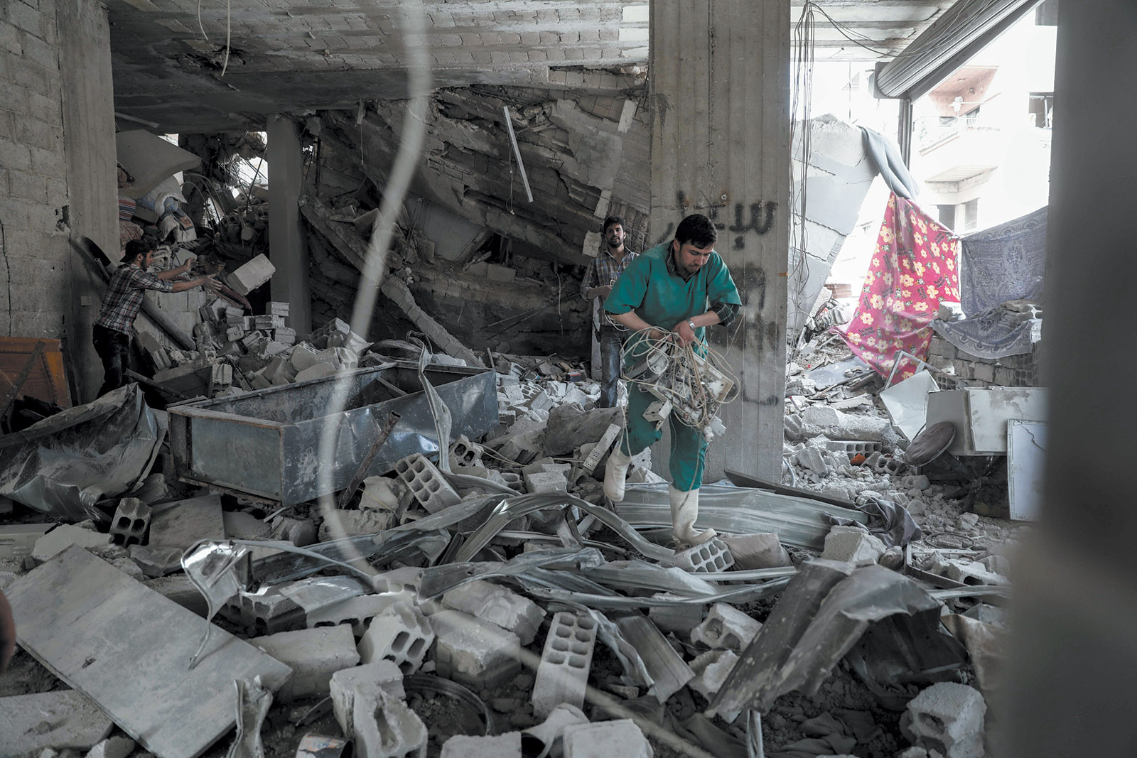 Men inspecting a hospital damaged by an air strike in Eastern Ghouta, Syria