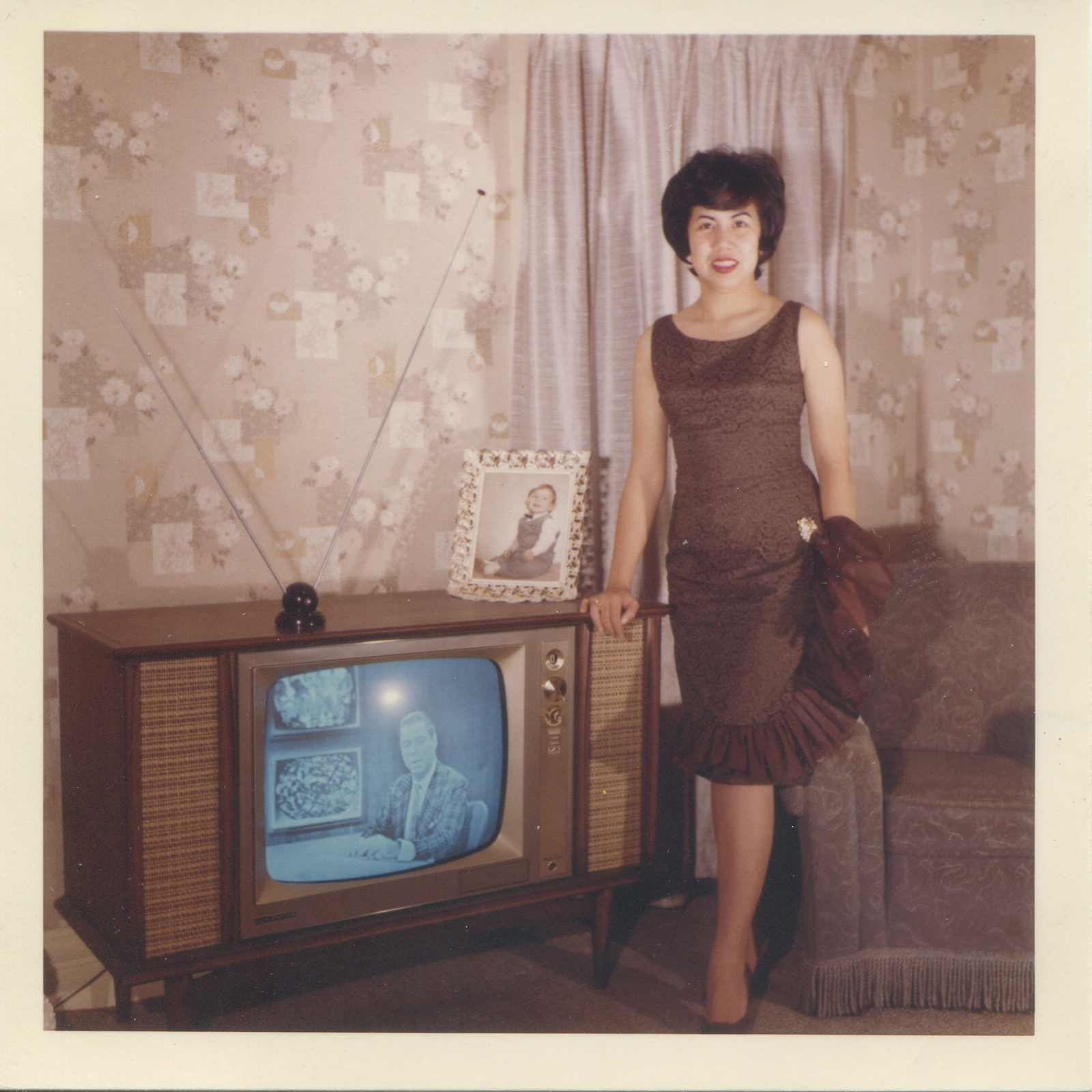 Woman in evening wear posing in front of TV