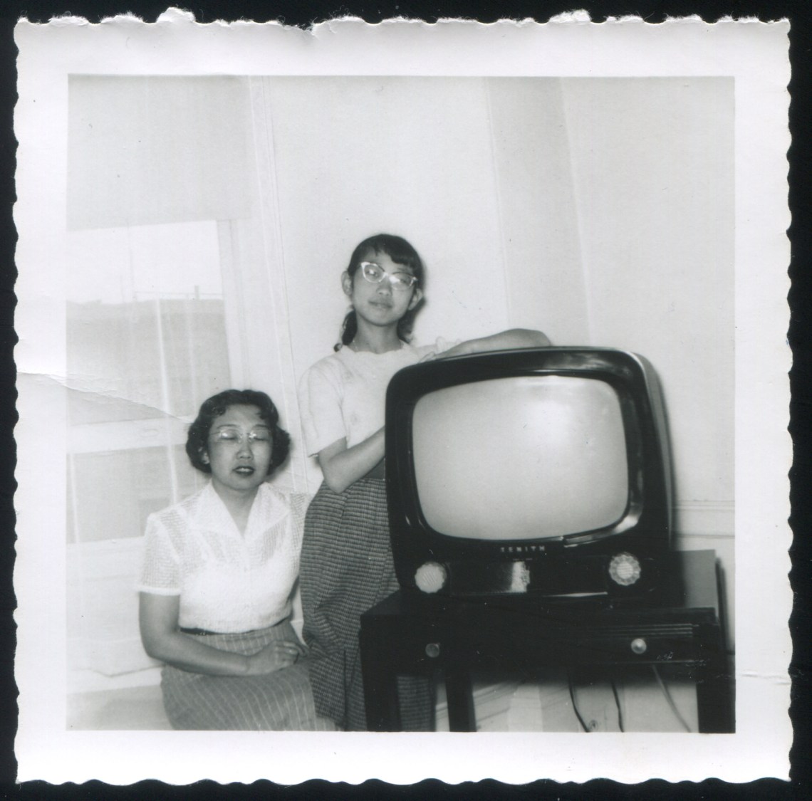 Two young people next to a TV