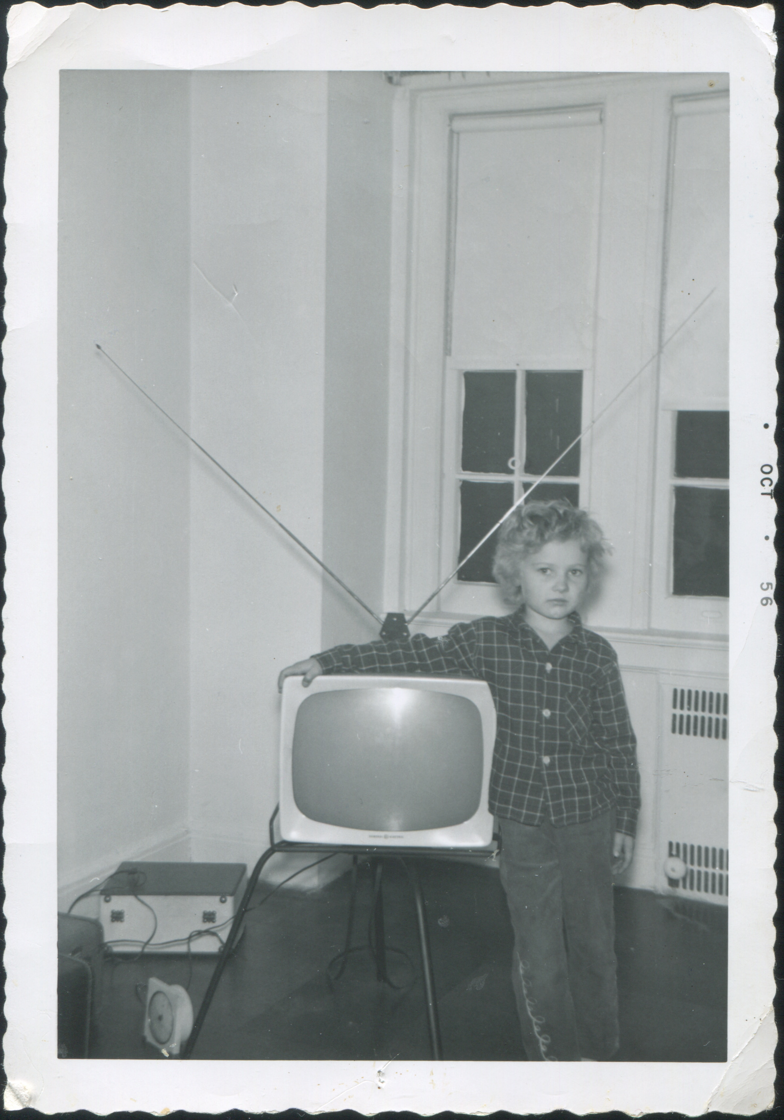Young child with arm around TV set