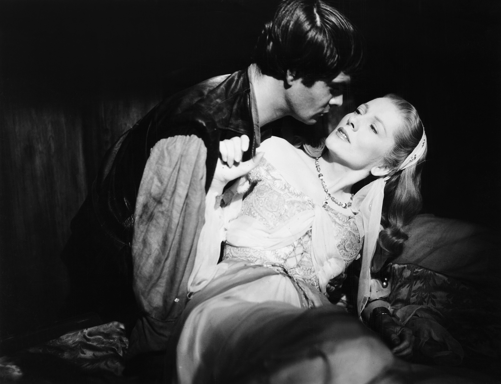 A black-and-white film still of a man and a woman about to kiss