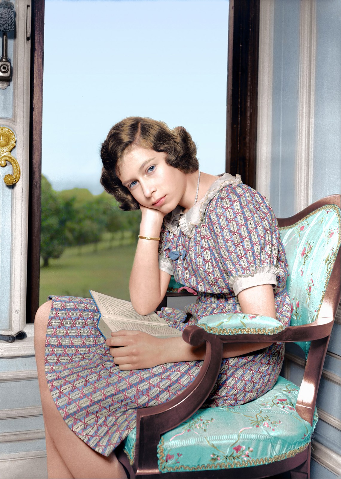 photo of Princess Elizabeth sitting in a chair with a book, Windsor Castle, 1940