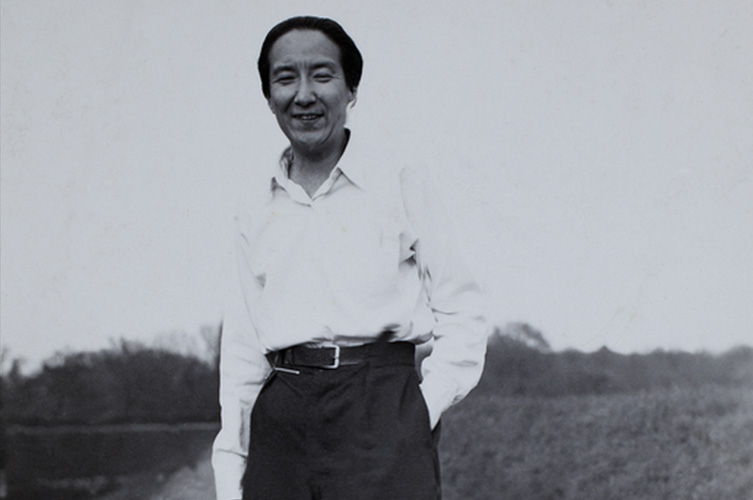 A black-and-white portrait of a woman wearing a white button-down shirt and trousers