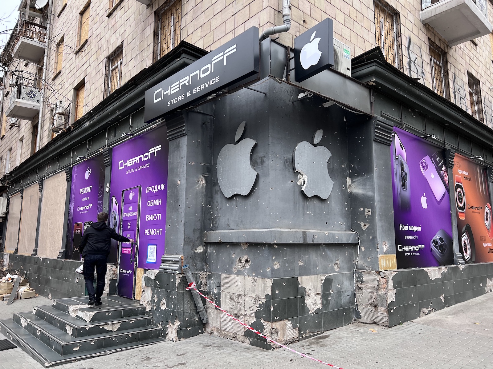 A bombed-out electronics shop with an Apple logo