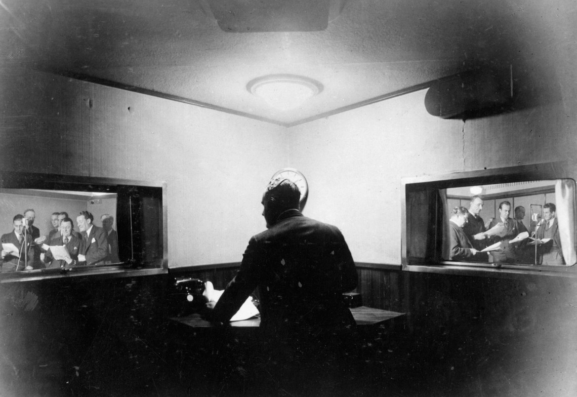 Two BBC programs being monitored from a control cubicle in Broadcasting House, London, 1932