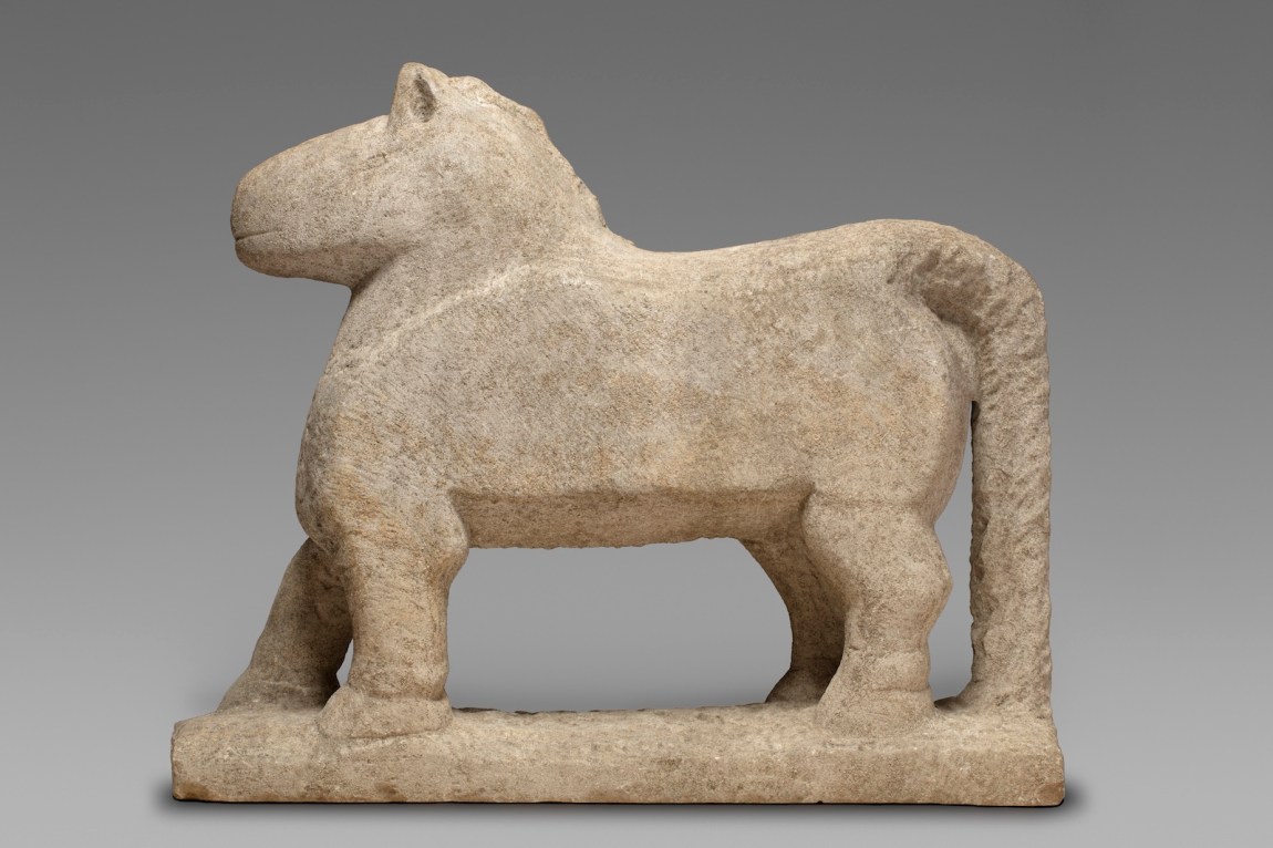 A carved limestone horse in profile