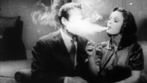 A still from Reefer Madness of a woman blowing smoke in a man's face