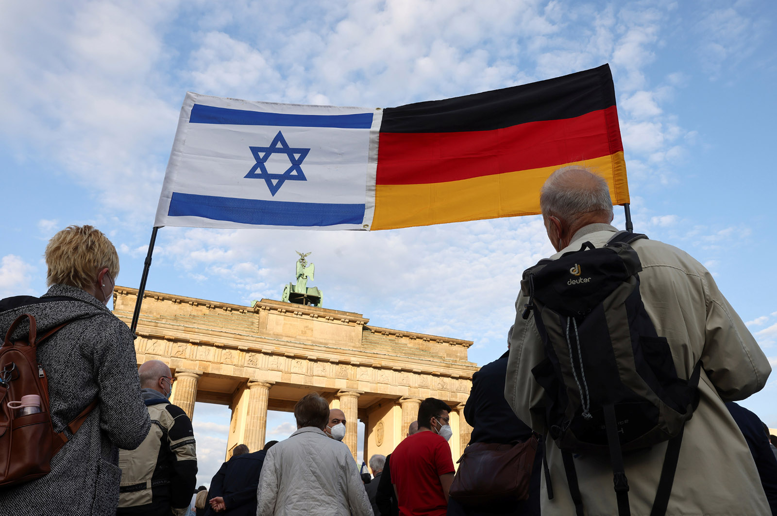 Bandiera israeliana e bandiera tedesca attaccate e tenute insieme in aria dai manifestanti contro l'antisemitismo, Porta di Brandeburgo, Berlino