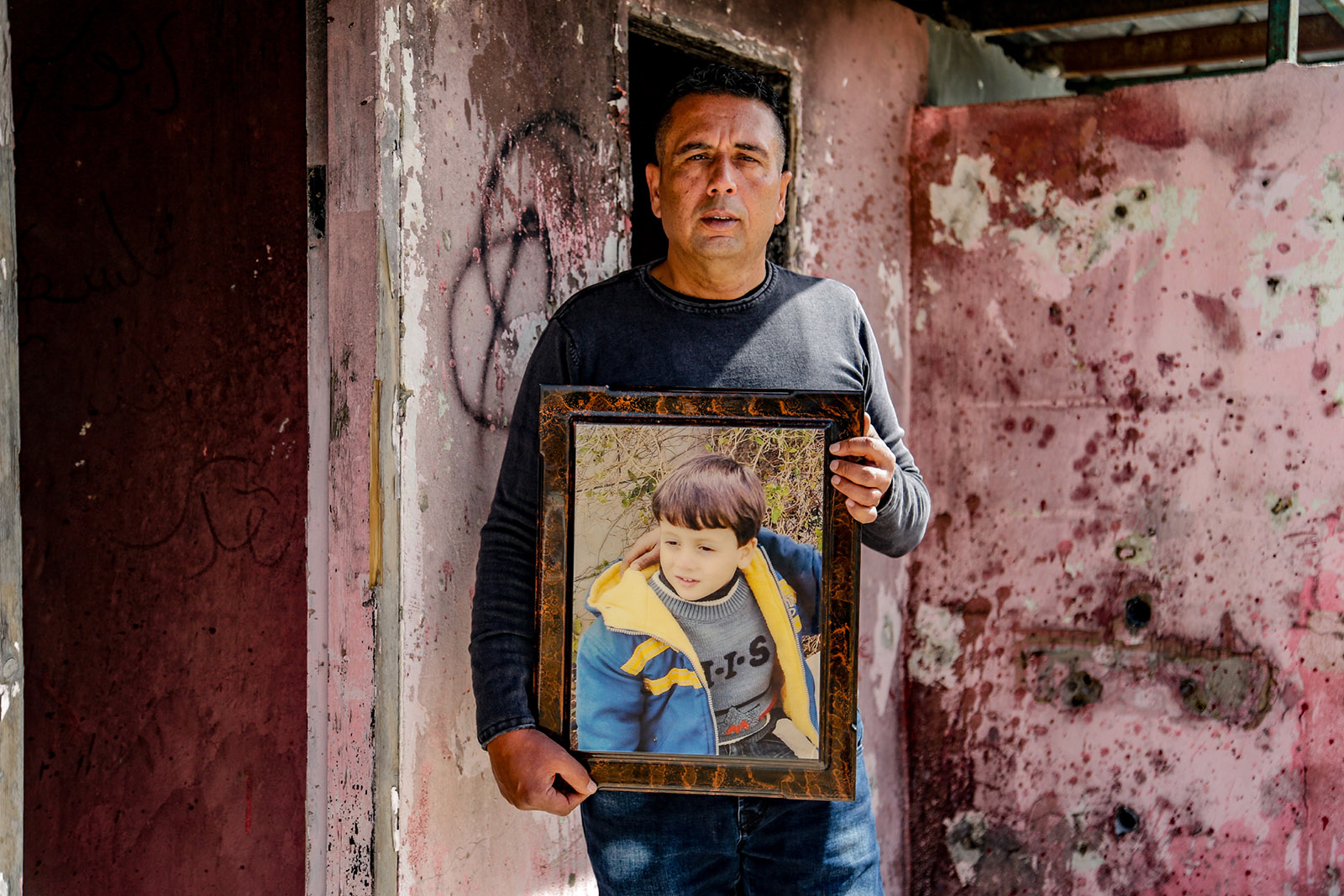 Abed Salama with a photograph of his son Milad, al-Bireh