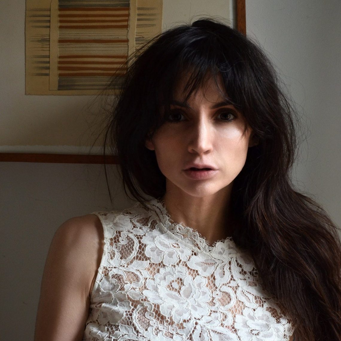 A headshot of Anahid Nersessian wearing a white lace top